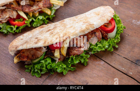Gyros, Shawarma, take away, Street Food. Sandwich mit Fleisch auf Holztisch, Detailansicht Stockfoto