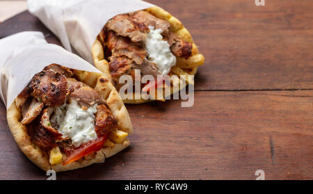 Gyros Pita, Shawarma, take away, Street Food. Zwei pita Brot Wraps mit Fleisch, traditionelle griechische türkisches Essen auf Holztisch, kopieren Raum Stockfoto