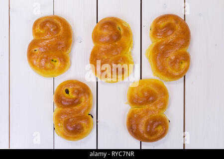 Fünf Suffron-Brötchen auf weißem Holz Stockfoto