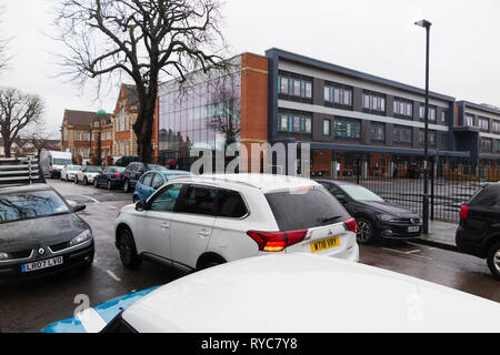 Geparkten Autos gefährlich/schlecht/illegal/Doppelzimmer/Doppelzimmer mit Warnblinkanlage während der Schule laufen Drop off/Sammlung UK blinken geparkt Stockfoto