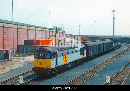 Eine Klasse 33 Crompton Diesellok Nummer 33207 und eine Klasse 08 Diesel Rangierlok Reihe 08542 Teilen die Pflicht, der gleichzeitig laden Rührstangen der Wagen über die RoRo-Brücke und auf die 'Nord Pas-de-Calais" Zug Fähre nach Dover Western Docks. 19. März 1993. Stockfoto