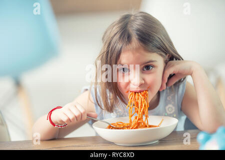 Süßes kleines Kind Mädchen essen spaghetti bolognese zu Hause. Stockfoto