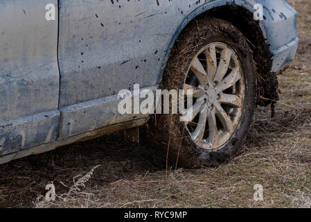 Schließen Sie schmutziges Auto mit trockenen Schlamm auf den Reifen Stockfoto