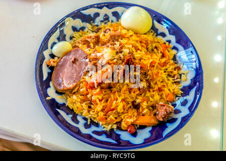 Usbekische traditionelle Lamm Pilav Fleisch Stücke Karotten Eier und Rosinen mit Reis Stockfoto