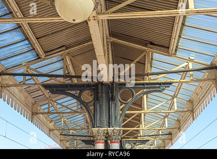 Eine reich verzierte 19. Jahrhundert Plattform Vordach an der York Railway Station. Dekorative Säulen halten ein Vordach aus Metall und Glas unter einem blauen Himmel. Stockfoto