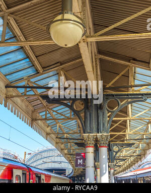 Eine reich verzierte 19. Jahrhundert Plattform Vordach an der York Railway Station. Dekorative Säulen halten ein Vordach aus Metall und Glas unter einem blauen Himmel. Stockfoto