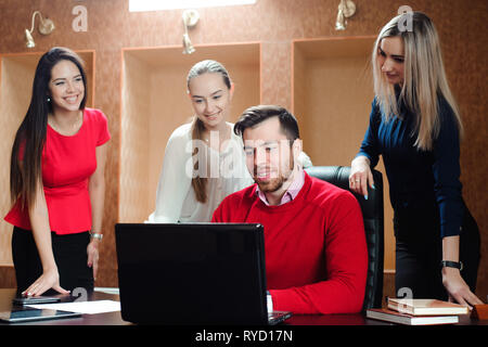 Gruppe von lächelnden inspiriert junge Geschäftsleute zusammen arbeiten im Büro. Stockfoto