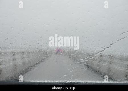 Alternative Perspektive von innen im Auto durch strömenden Regen Stockfoto