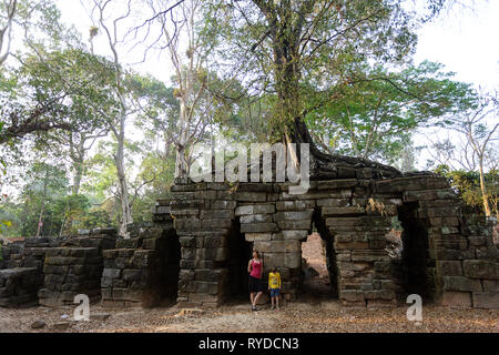 Mutter und Sohn, der an alten Spean Thmor Brücke, durch einen Baum überwachsen, Weltkulturerbe Angkor, Siem Reap, Kambodscha Stockfoto