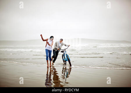 Glückliches junges Paar spielen in das Meer bei Ebbe. Stockfoto