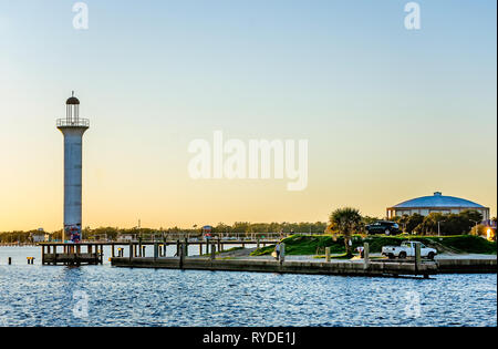 Die Sonne geht auf das Broadwater Beach Marina Kanal Leuchtturm und Mississippi Gulf Coast Coliseum (rechts), 24.02.2019, in Biloxi, Mississippi. Stockfoto