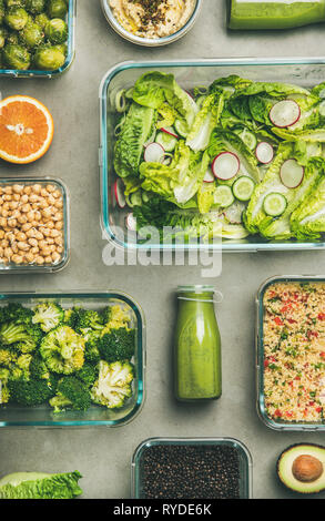 Gesunde vegane Gerichte in Glasbehältern. Flachbild-lay von Gemüse Salate, Hülsenfrüchte, Bohnen, Oliven, Sprossen, Hummus und frische Säfte in Flaschen über concr Stockfoto