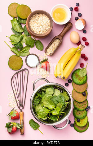 Spinat Pfannkuchen und Zutaten, flach auf rosa Hintergrund legen Stockfoto