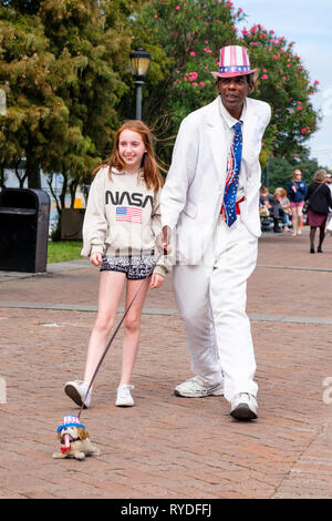 Onkel Louie, ein Straßenkünstler, Straßenmusiker, Busking, der sich als lebende Statue mit einem jungen Touristen am Mississippi River, im French Quarter von New Orleans, posiert. Stockfoto