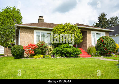 Durchschnittliche Wohnhaus mit üppigen Vorgarten Rasen an bewölkten Tag Stockfoto