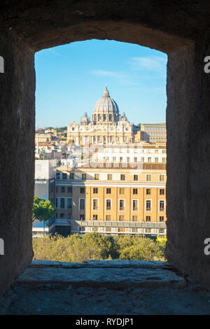 Vatikan Vatikan - Februar 4, 2018: Ansicht der Basilika St. Peter an einem Fenster in Castel Sant'Angelo eingerahmt. Vertikale Stockfoto