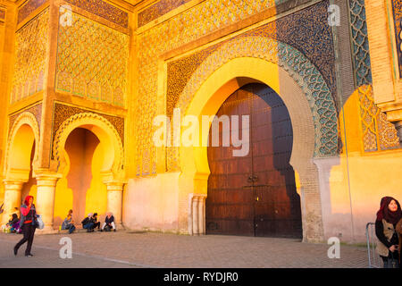 Meknes, Marokko - April 4, 2018: Marokkaner vor der Bab Al-Mansour historischen Tor während der Goldenen Stunde zu spät am Nachmittag. Horizontale Stockfoto