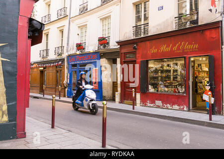 Paris motor scooter - einen Mann auf Roller fahren durch die rue Guisarde im 6. arrondissement von Paris, Frankreich, Europa. Stockfoto