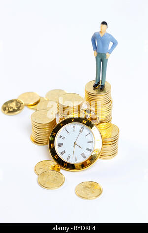 Goldmünzen und Uhr Stockfoto