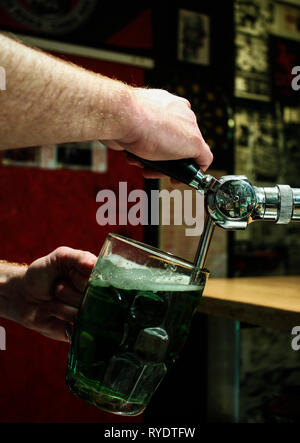 Gießen grün Bier im Glas Krug von Barkeeper in Irish Pub oder einige andere Bier Tempel aka Beer House Stockfoto