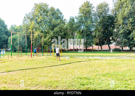 Riwne, Ukraine - 21. August 2018: rowno Stadt in der westlichen Ukraine und Mann spielt mit Hund im Park Feld mit Trainingsgeräten bars Stockfoto