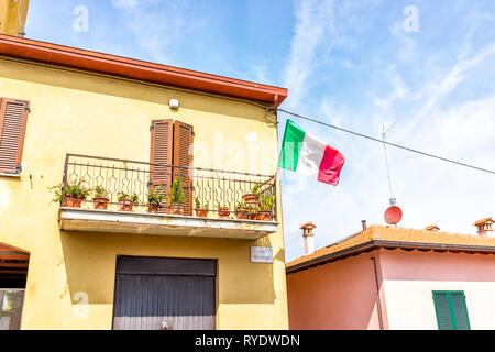 Chiusi, Italien Straße mit italienischer Flagge auf Außen hängend auf dem Balkon der Wohnung in kleinen mittelalterlichen Stadt Dorf in Umbrien während d Stockfoto