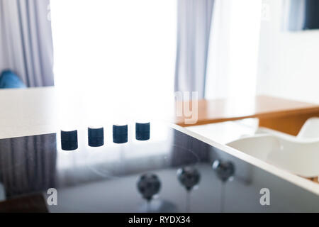 Nahaufnahme der Drehknöpfe auf modernen Luxus elektrische Kochen Kochfeld Kochfeld mit Glas Reflexion und Kreise Hintergrund in leer Startseite Stockfoto