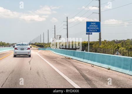 Key Largo, USA - 30. April 2018: die Tasten Auto auf dem Overseas Highway Road in Florida mit Vorzeichen in der Nähe von Miami Dade Juvenile Wohnanlage Stockfoto