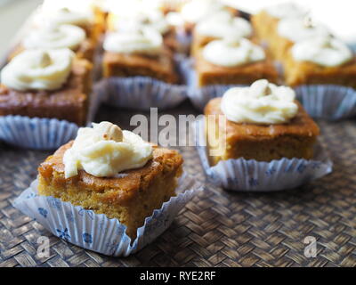 Stück Karottenkuchen mit Cream Cheese frosting auf Holz Fach Stockfoto