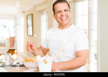 Mittleres Alter mann Essen asiatische Küche zu Hause. Stockfoto