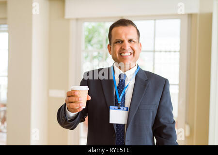 Mittleres Alter Geschäftsmann, trinken eine Tasse Kaffee tragen ID-Karte Stockfoto