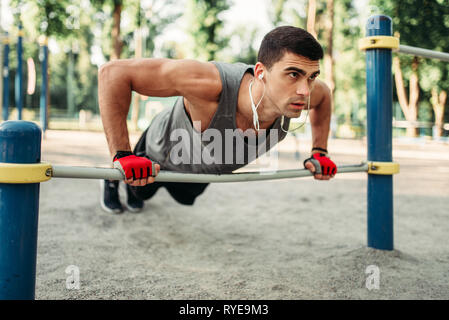 Man Push-up, Übung mit horizontalen Balken Stockfoto