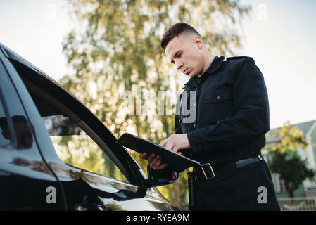 Polizisten in Uniform schreibt fein zu weiblichen Treiber Stockfoto