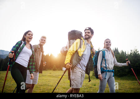 Gruppe der Wanderer mit Rucksack und Stöcke zu Fuß auf den Berg. Freunde machen einen Ausflug Stockfoto