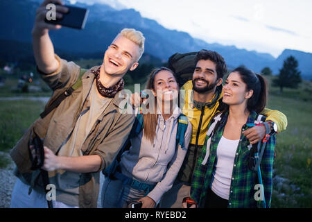 Gruppe von Freunden, die Ruhe am Berg beim Wandern. Wanderer, die entspannende und nehmen Selfie. Stockfoto