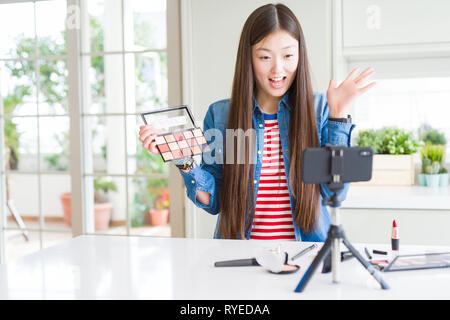 Schöne asiatische Einflussnehmer Frau Aufnahme Make-up Tutorial über Smartphone-kamera sehr glücklich und aufgeregt, Sieger Ausdruck feiern Sieg scre Stockfoto