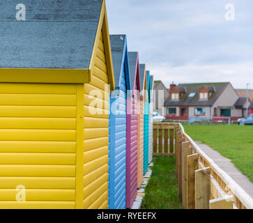 Schlendern, Northumberland, Großbritannien - Februar 2017: Bunte Hütten (gelb, blau, pink, grün) in der Nähe vom Strand entfernt Stockfoto