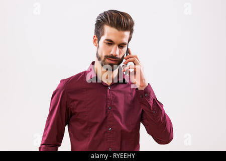 Studio shot Porträt junger Geschäftsmann, der am Telefon sprechen. Stockfoto