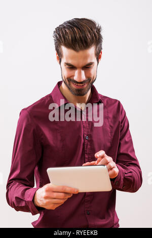 Studio shot Porträt junger erfolgreicher Geschäftsmann, der sich mit Tabletten. Stockfoto
