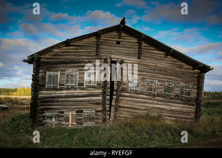 Vorderansicht des Holz- Haus in russischen Dorf Anmelden an einem sonnigen Tag gegen helles bewölkten Himmel und Herbst Hintergrund Landschaft, Haus auseinander gerissen. Stockfoto