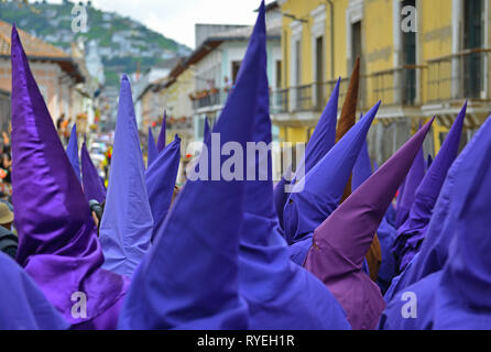 Die lila Büßer nannte die cucuruchos Wandern in den Straßen von Quito in der Osterzeit Prozession in lila Kleidung am Heiligen Freitag, Ecuador. Stockfoto