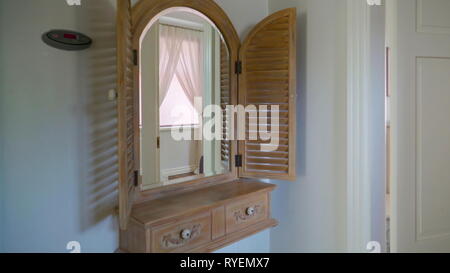 Eine braune Farbe Kommode im Schlafzimmer des Hauses mit dem Blick des kleinen weißen Knopf und ein geformtes Design auf Stockfoto