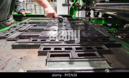 Schrubben von schwarzer Tinte auf der Apple metall Formen innerhalb der alten Druckerei Stockfoto