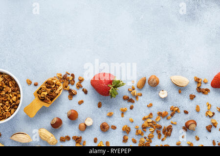 Müsli, Erdbeeren und Zutaten - Hafer, verschiedene Nüsse und Honig. Gesundes Frühstück Hintergrund mit kopieren. Stockfoto