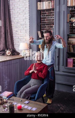 Schön langhaarigen Mann, der ein magisches Ritual Stockfoto