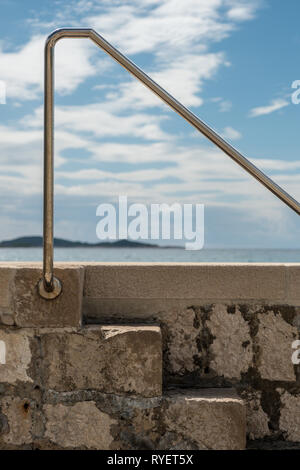 Ein Geländer und Treppen, die zum Wasser an einem sonnigen Sommer in Mlini, Kroatien Stockfoto