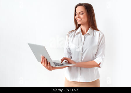 Moderne Technologie. Frau, die isoliert auf weißem Surfen im Internet auf dem Laptop freudige Stockfoto