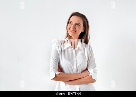 Freestyle. Frau, die isoliert auf weißem verschränkten Armen denken kreativ Stockfoto