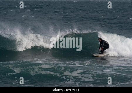 Surfer am Gyllyngvase Beach, Falmouth in drei bis vier Fuß Surf Stockfoto