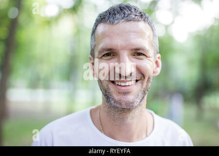 Portrait von Happy attraktiver Mann an der Kamera im Freien suchen Stockfoto